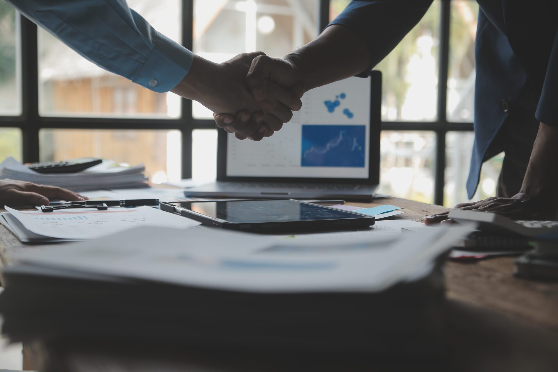 Business success. Businesspeople shake hands to confirm agreemen What We Have to Offer